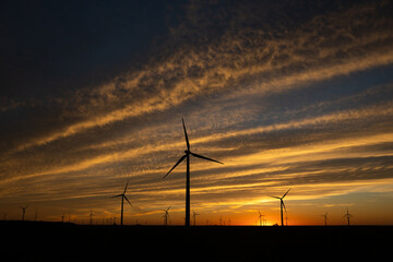 Fototapeta na wymiar Sunset behind a field of wind turbines