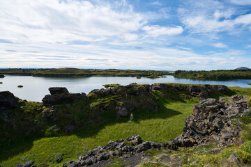 A sunny day on lake Myvatn, Iceland. Clouds reflected in the blue water of a volcanic lake.
