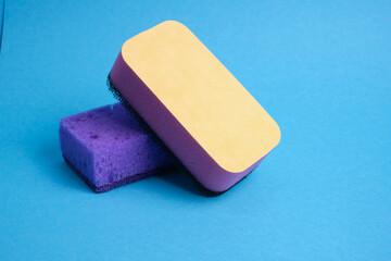 different types of purple kitchen cleaning sponges on blue background