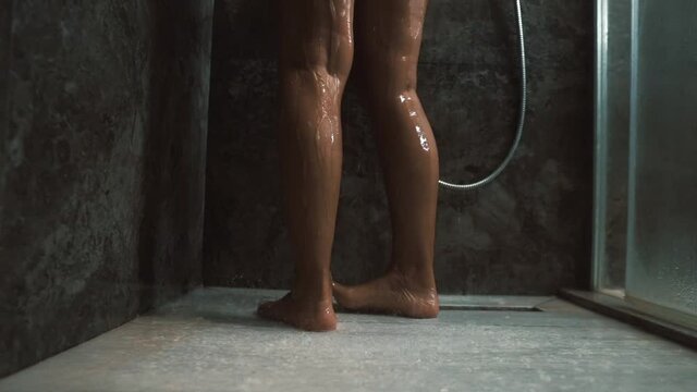 Taking shower. Woman standing in shower cabin under splashing water