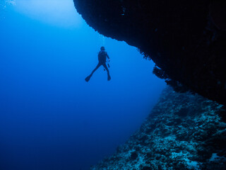 青い海を背景に中性浮力を保つダイバーのシルエット。沖縄県伊江島