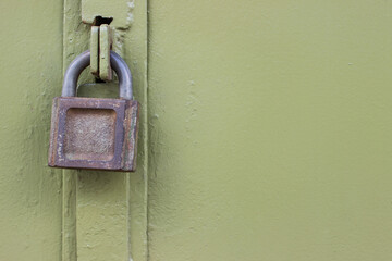 Old rusty padlock on a metal door. Copy space.