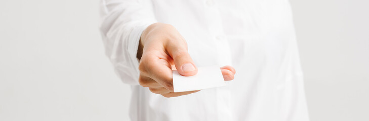  girl in a white office shirt holds out a business card. close portrait. High quality photo