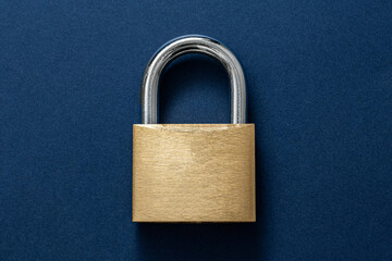 Fototapeta premium Locked Golden Padlock on the blue background.