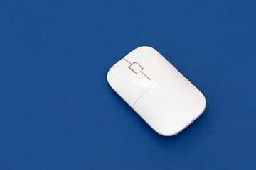 White computer mouse on the blue background.