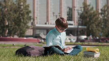 Online education, Back to school, Happy schoolboy, Learn lessons. Schoolboy doing homework using a notebook and a book