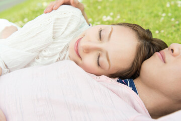Obraz na płótnie Canvas 芝生に寝そべるカップル