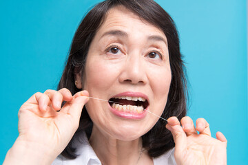 デンタルフロスをするミドル女性