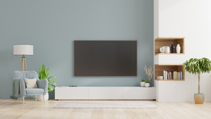 TV on cabinet in modern living room,Interior of a bright living room with armchair on empty blue wall background.
