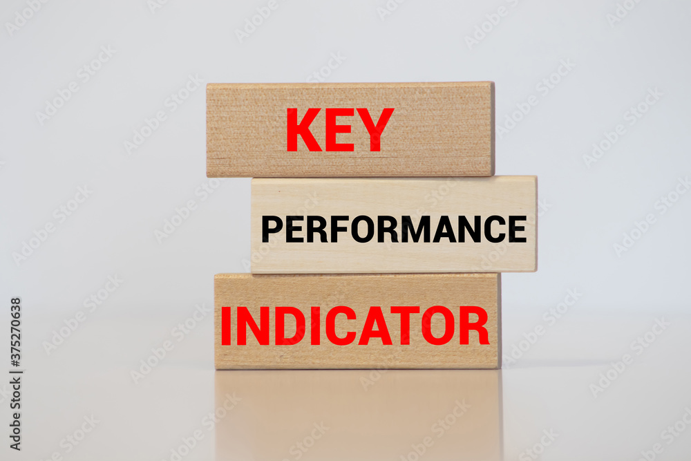 Poster wooden cube block with key, performance and indicator word on table background. business concept