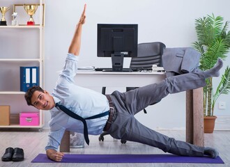 Businessman doing sports in office during break