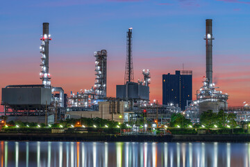 Oil refinery reflected along with river during twilight