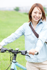 Obraz premium 自転車を押して歩く女性