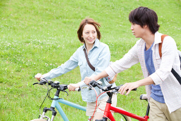 自転車を押して歩くカップル