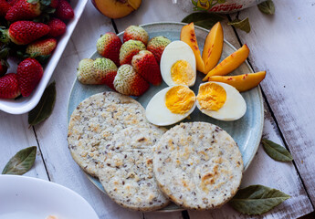 Breakfast with arepa and fruits like peach strawberries and avocado