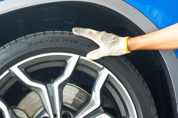 Hand of mechanic on the tire to check the Tire Size numbers and  Tyre Load Indexes on the sidewall.
