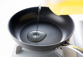 Pour oil into the frying pan. - obrazy, fototapety, plakaty