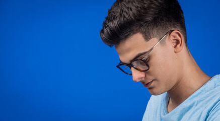 Joven con lentes en fondo azul