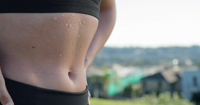 Female stomach with sweat dripping down abs