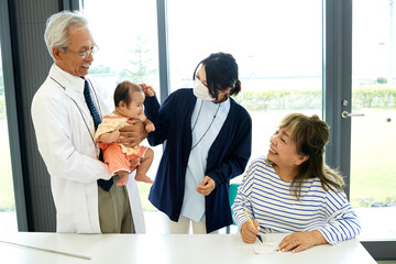 Fototapeta na wymiar リハビリ中の患者と医療スタッフと赤ちゃん