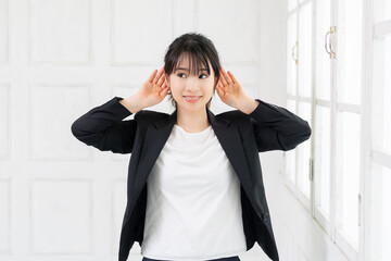 聞き耳をたてる若いビジネスウーマン