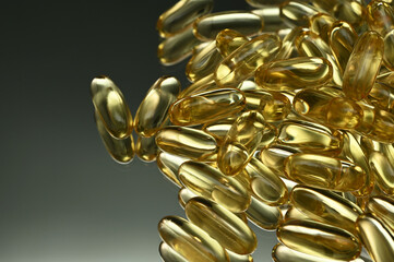 Fish oil capsules with omega 3 and vitamin D on a mirror, shiny texture, healthy lifestyle, diet concept