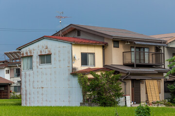 Fototapeta na wymiar 夏の田舎の水田と隣の民家の家の風景