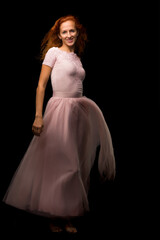 A beautiful young woman stands in the wind, the wind moves her clothes and hair.