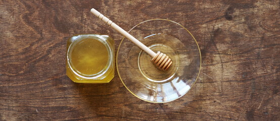 The idea of natural products. On a wooden natural ancient background honey and a spoon with honey.