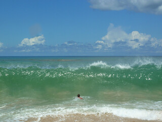 high  wave and man back in ocean water waiting for wave