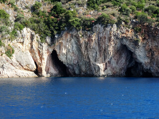Fototapeta na wymiar Natural sea caves of Ionian island near Nydri village in Lefkada in Greece. Tourists visit Nydri for vacations for its natural mountainous and seascape, also choices of bars and restaurants.