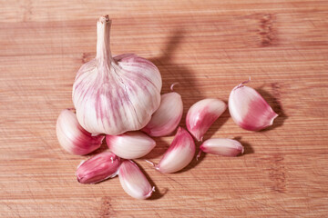 Garlic head and garlic cloves on a wooden background.