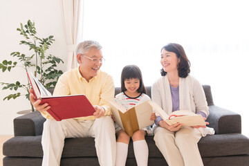 本を読む祖父母と孫