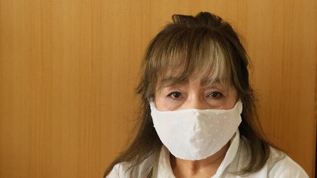 避難所イメージ　災害にあって避難所の体育館に避難してきたシニア女性