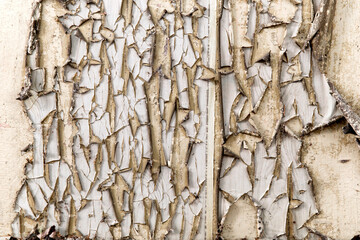 Old background with peeling paint cracks and chips. Beige orange texture with large chunks of old...
