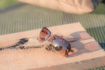 Retro sunglasses model with red lenses shoot in a sunny day in nature closeup. Selective focus