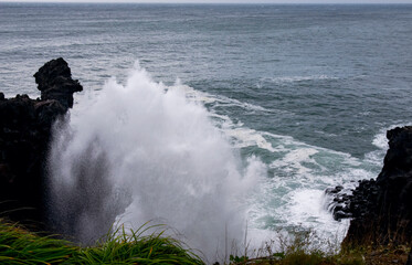 Huge waves scattering through coastal rocks