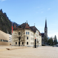The old Liechtenstein Parliament building and the tower of the Cathedral of Saint Florin at sunset.