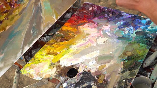 Art palette. Artist paints a picture of oil paints. Artist brush mixed color oil painting on palette. Palette with paintbrush