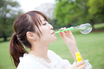 しゃぼん玉を吹く女性