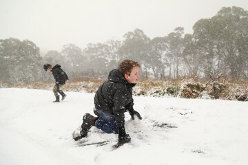 Fototapeta na wymiar Happy boys playing in snow storm in New South Wales, Australia
