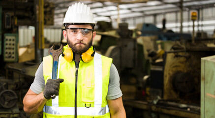 Portrait of male bearded engineer in the factory.