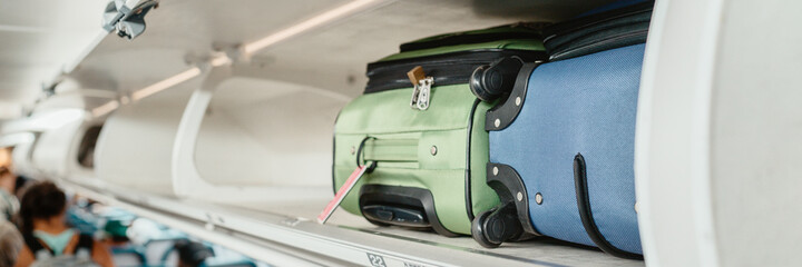 Carry-on luggages in overhead compartment of plane for international flights. Travel restrictions...