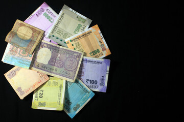 Now and old Indian currencies. 50, 100, 200, 500 rupee notes and coins. Indian currency isolated on black background.