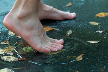 teen walks through puddles after summer rain