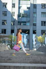 Trendy cute young woman carrying shopping bags