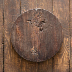 round wooden plate on old wooden background