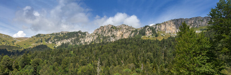 Panorama of the mountain range against the blue sky on a Sunny summer morning.