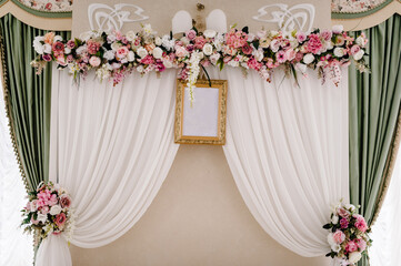 Festive table, arch, stands decorated with composition of violet, purple, pink flowers and greenery in the banquet hall. Table newlyweds in the banquet area on wedding party.