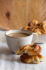 close-up of sweet pastries with a cup of coffee on the table on a wooden background